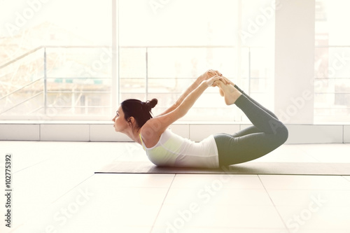 Yoga concept. Young attractive woman does exercises, close up