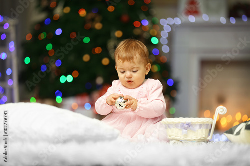 Sweet baby girl with jingle bell on Christmas background