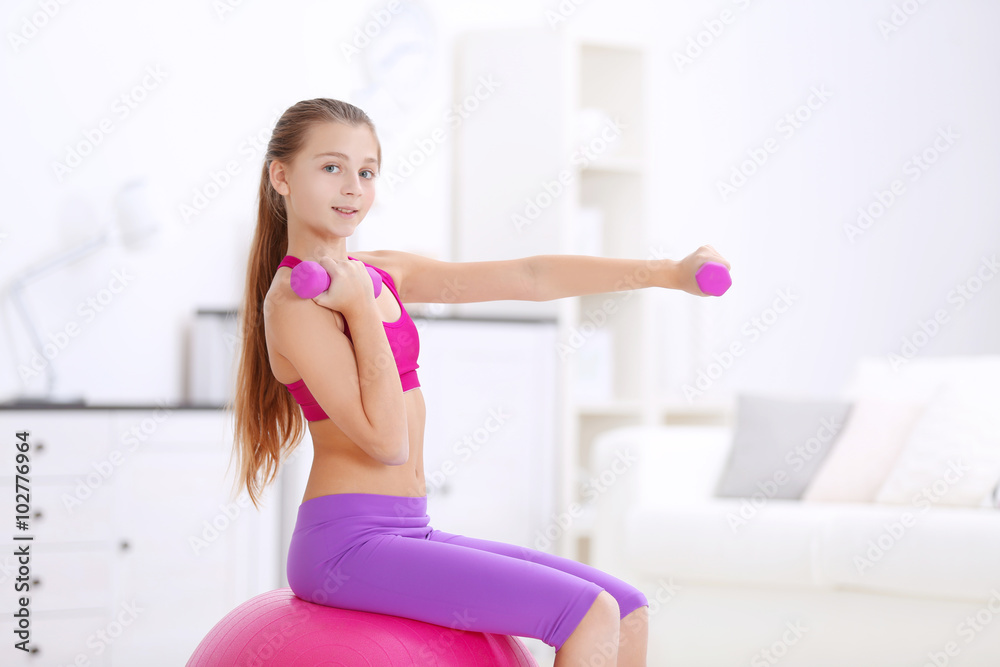 Young girl making fitness exercise with fir ball indoors Young girl making fitness exercise with fir ball indoors