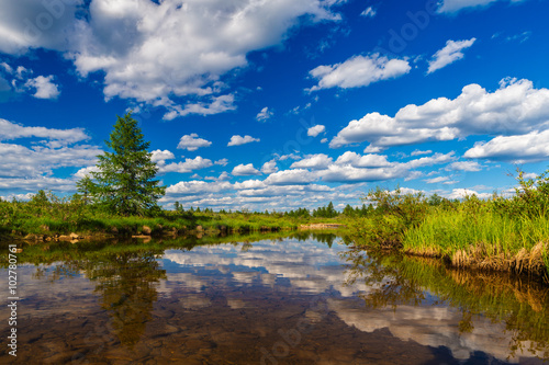 Summer landscape with clouds on the blue sky and river and cliffs 