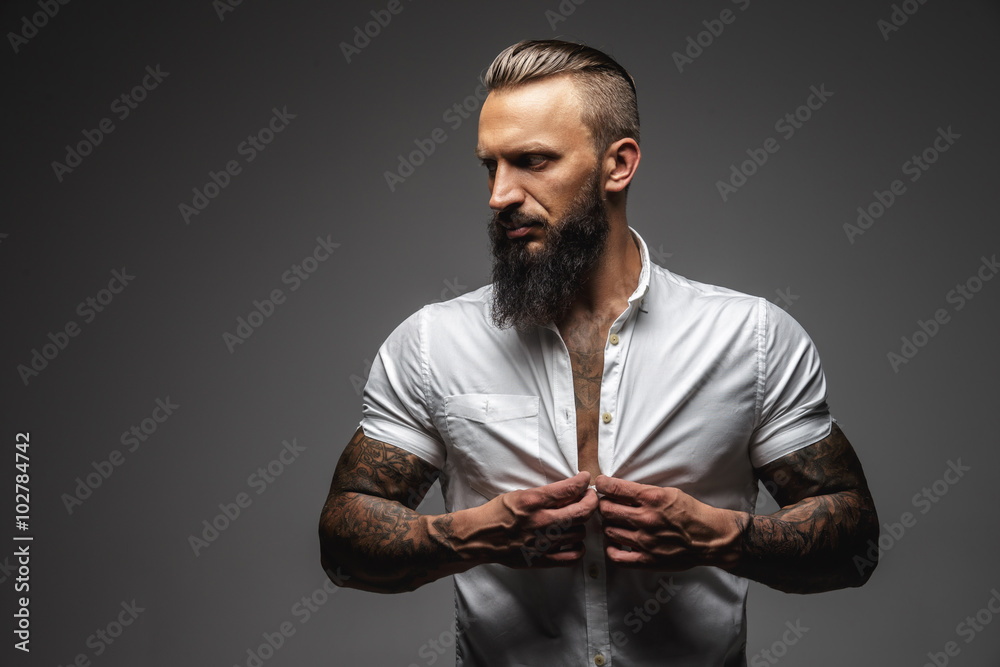 Bearded muscular man in a white shirt.