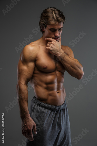  Muscular guy isolated on a grey background.