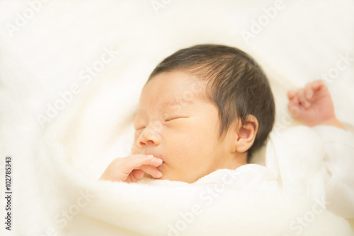 タオルに包まれて眠る新生児