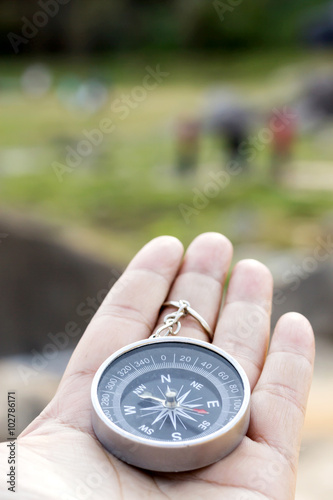 Female traveler holding a compass on nature