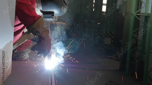workers welding metal parts in big modern shipyard
