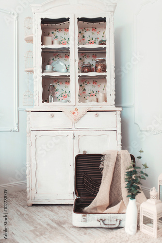 Beautiful vintage white suitcase lies open on the floor in the room