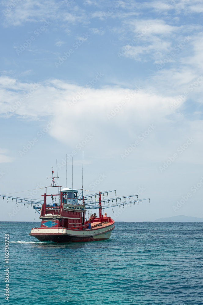 Red Fishing vessel moving at low speed