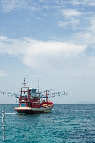 Red Fishing vessel moving at low speed