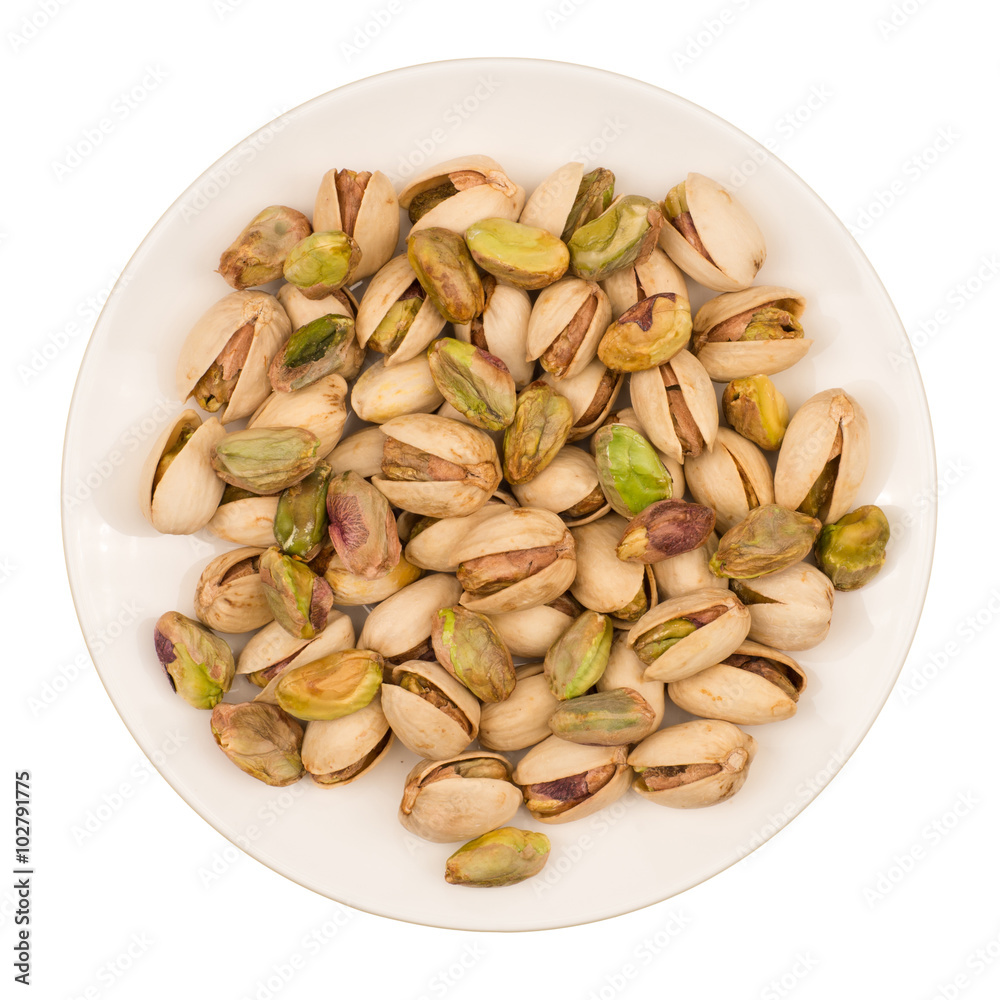 Roasted pistachio nuts in plate, isolated on white background. Roasted pistachio nuts in plate, isolated on white background.