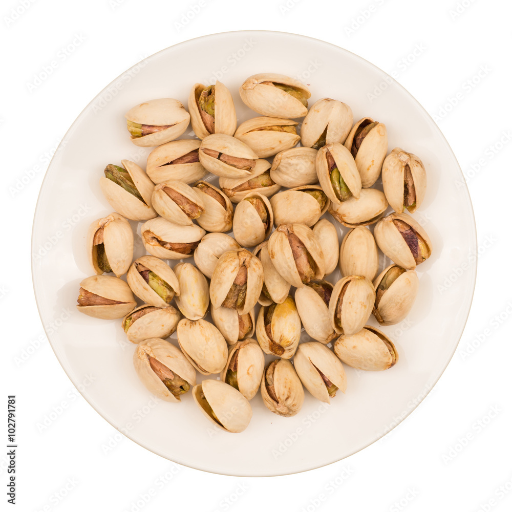Roasted pistachio nuts in plate, isolated on white background. Roasted pistachio nuts in plate, isolated on white background.