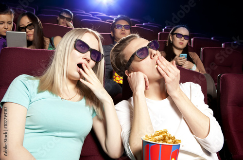 People sitting at the cinema, watching a film