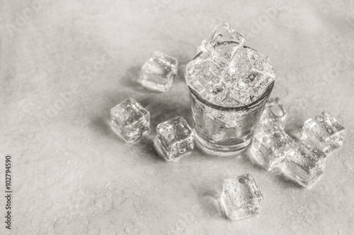 glass of ice cube on wet floor