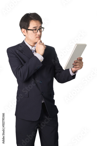 Asian businessman reading notebook or diary for checking, isolat