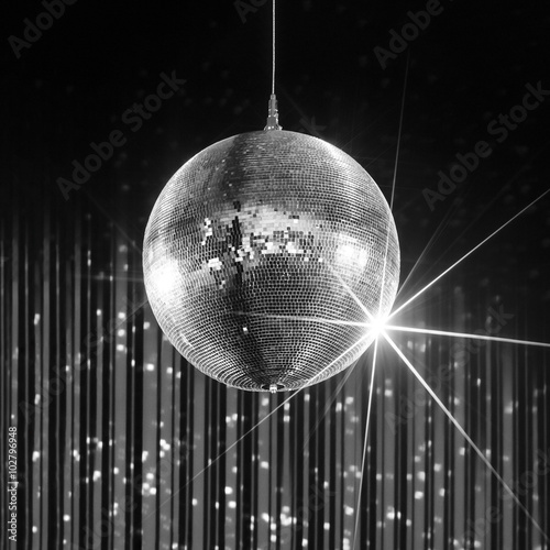 Party disco ball with stars in nightclub with striped walls lit by spotlight, nightlife entertainment industry, monochrome