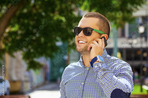 Happy young men calling by phone