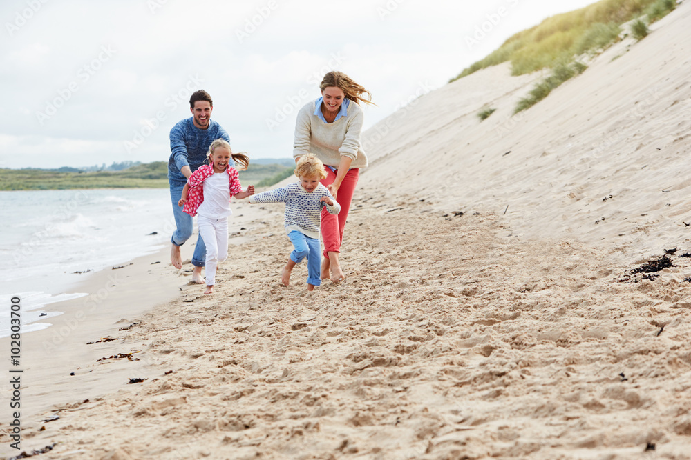 Family On Beach Vacation Running By Sea