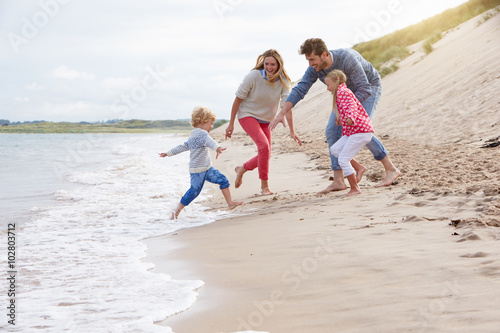 Family On Beach Vacation Playing By Sea