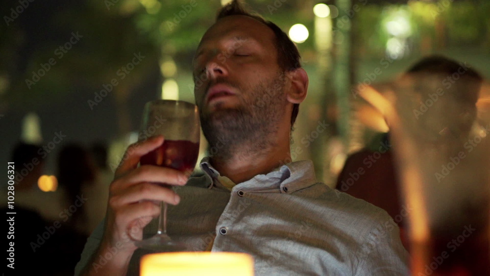 Young drunk man sitting in bar during night
