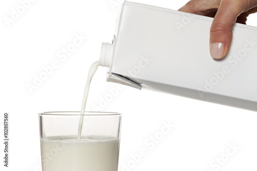 pouring milk from the carton into a glass