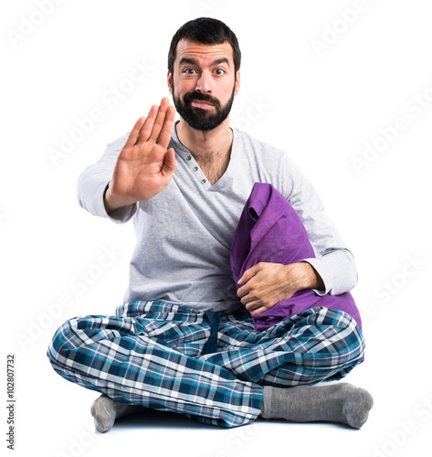 Man in pajamas making stop sign