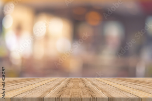 Wooden board empty table in front of blurred background. Perspective brown wood over blur in restaurant - can be used for display or montage your products.Mock up for display of product. photo