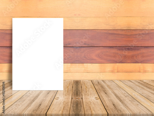 Blank poster leaning at plank wood wall and diagonal wooden floor Mock up for adding your design.