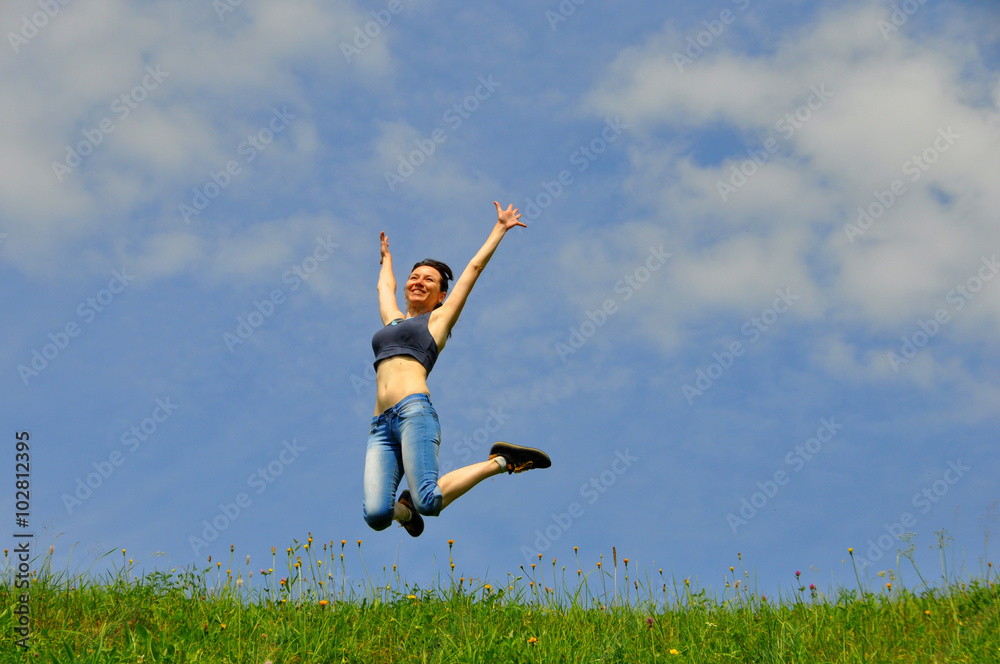 Beautiful and happy girl jumps high on grass Beautiful and happy girl jumps high on grass