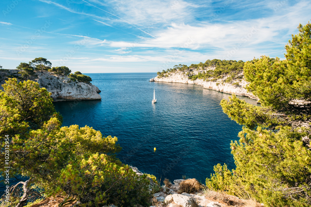 Obraz premium Boat leaves from bay to open sea in Calanques on the azure coast