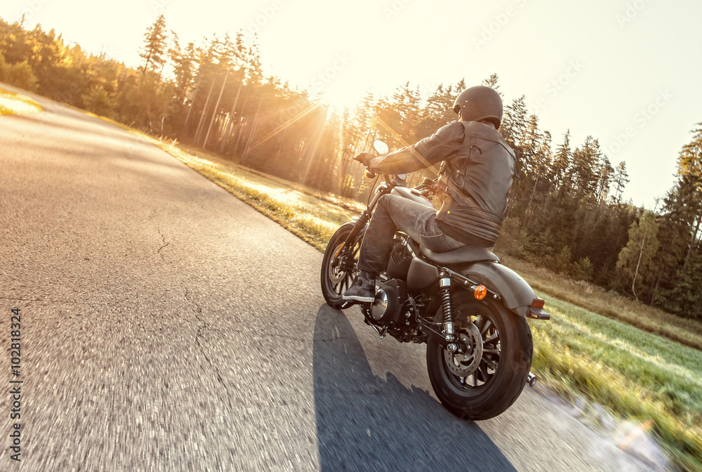 Fototapeta premium Siedzenie człowieka na motocyklu na leśnej drodze.