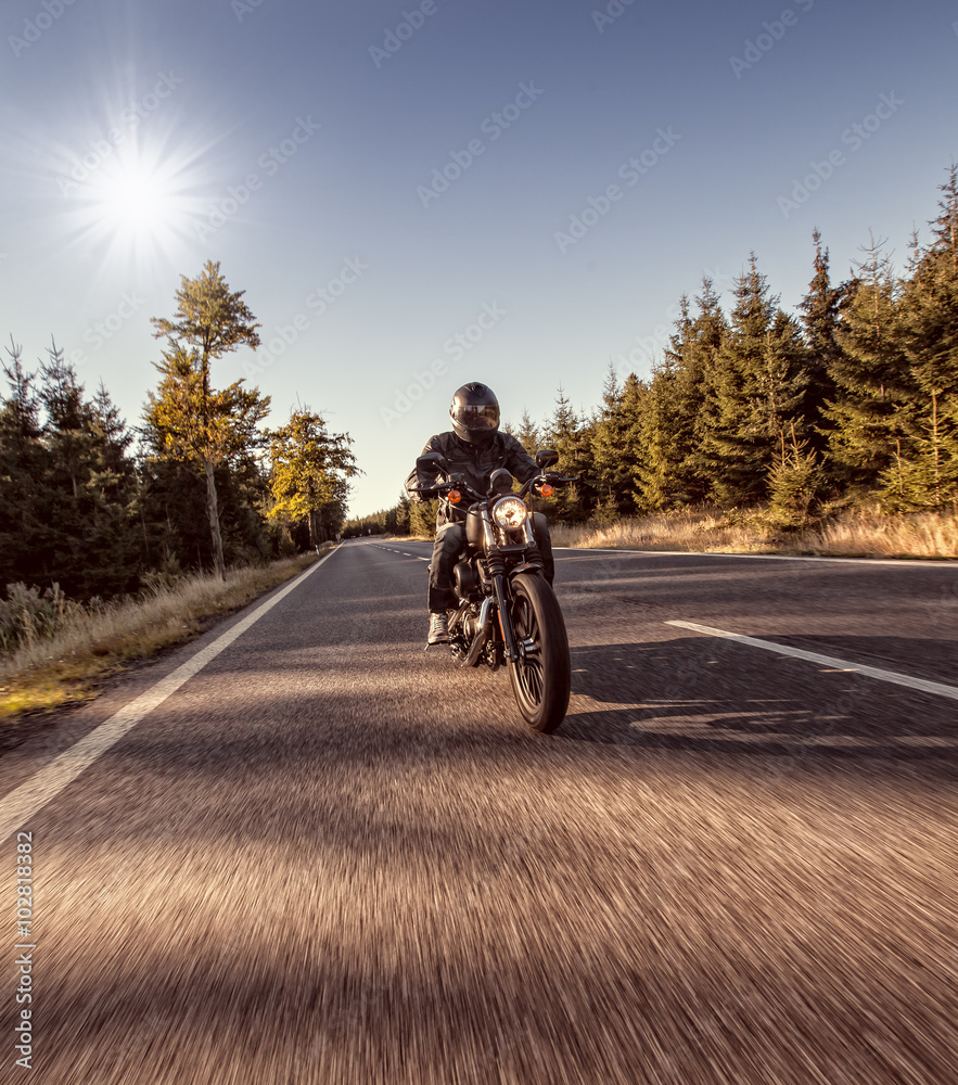 Naklejka premium Man seat on the motorcycle on the forest road.