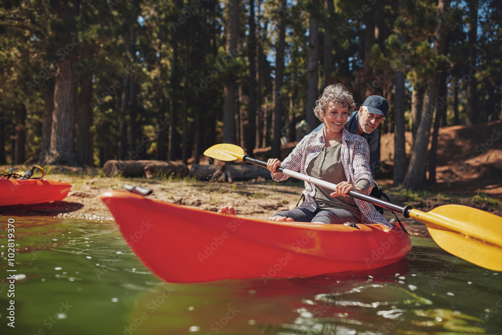 Mature woman learning to row in kayak Stock Photo | Adobe Stock