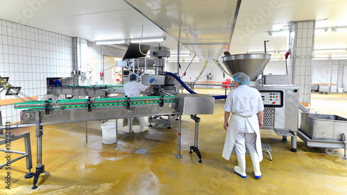 Lebensmittelfabrik - Herstellung von Würsten am Fliessband - Interieur einer Großfleischerei // food factory - production of sausages on an assembly line - interior of a large butcher photo