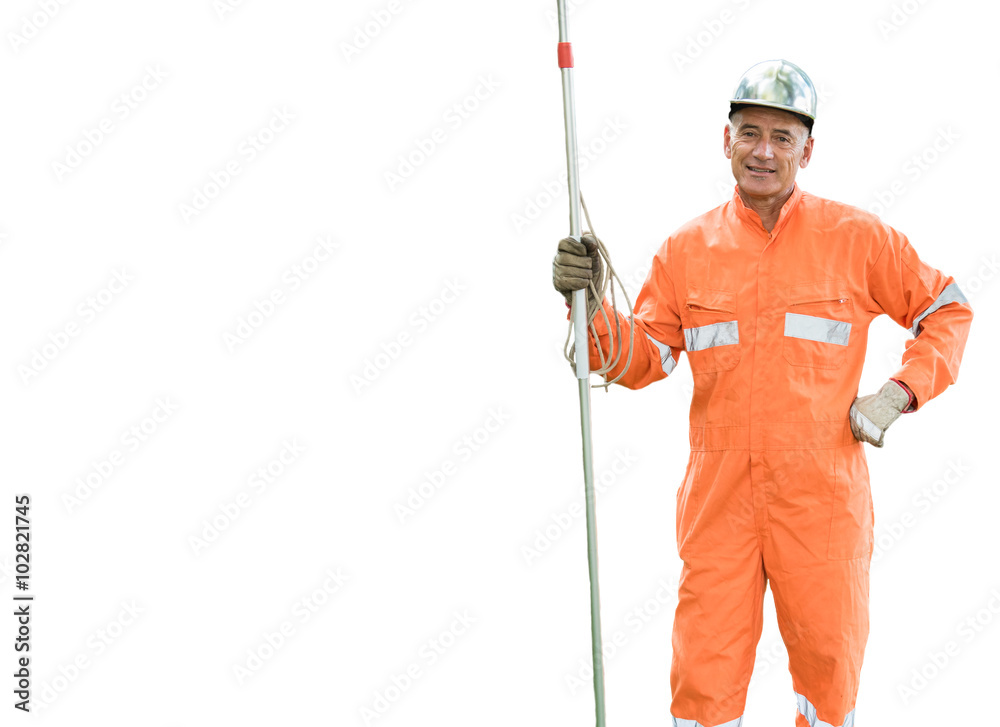 Adult worker wearing an orange safety suit and helmet. He is pruning and measuring trees. Adult worker wearing an orange safety suit and helmet. He is pruning and measuring trees.