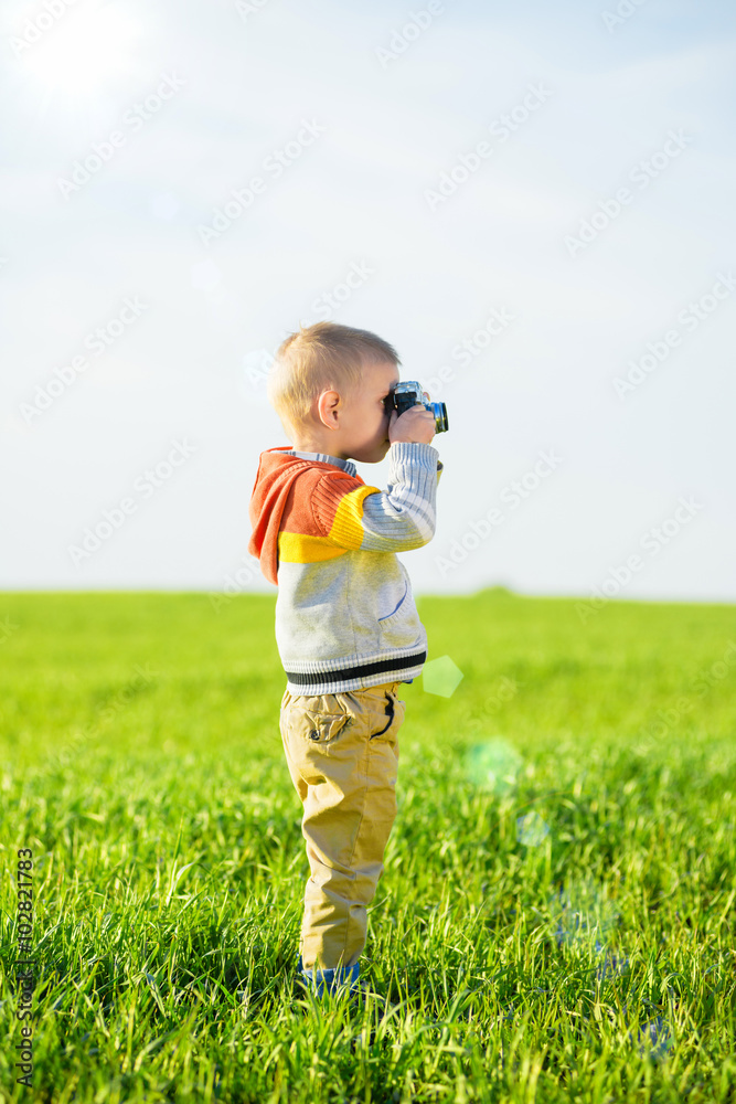 Little boy with an old camera shooting outdoor. Little boy with an old camera shooting outdoor.