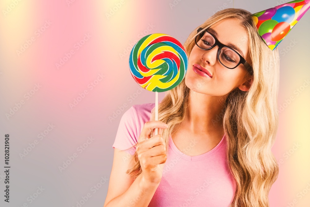 Composite image of a beautiful hipster holding a giant lollipop 