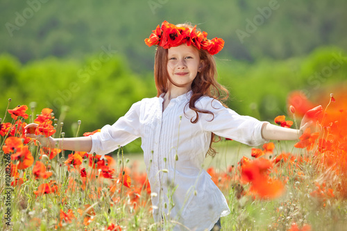 Beautiful kid in a red flowers field 