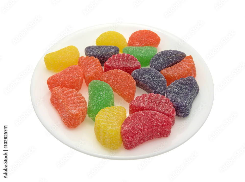 Side view of candy fruit flavored slices on a plate isolated on a white background Side view of candy fruit flavored slices on a plate isolated on a white background
