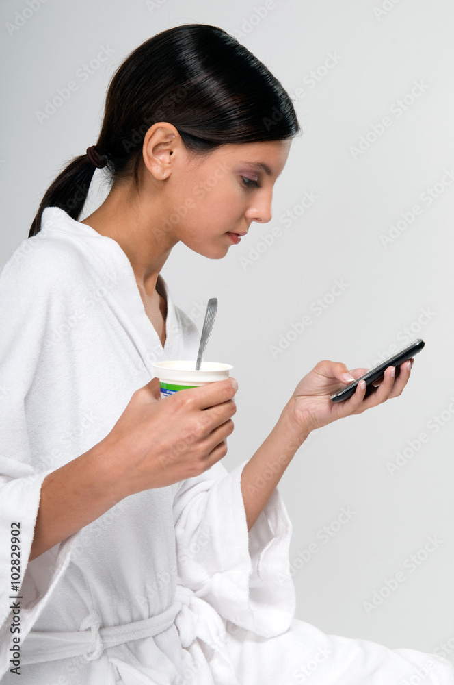 Woman eating a yogurt while chating