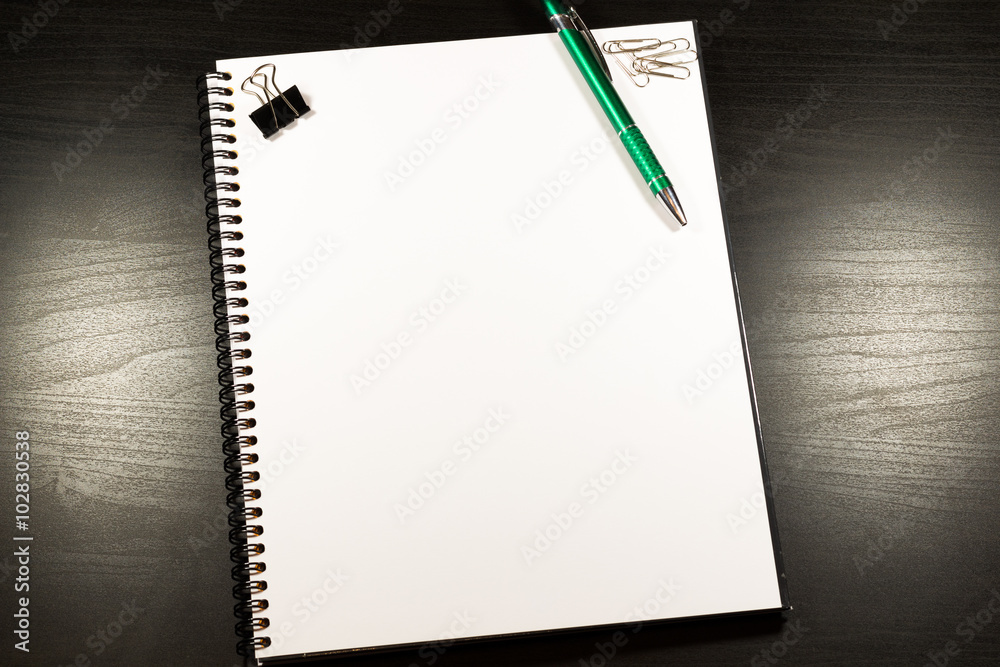 Notebook with blank paper, color sticky notes, pen and clips on a wooden table Notebook with blank paper, color sticky notes, pen and clips on a wooden table