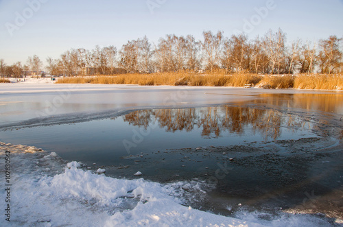 Beautiful landscape, the river ice melts in the evening sun