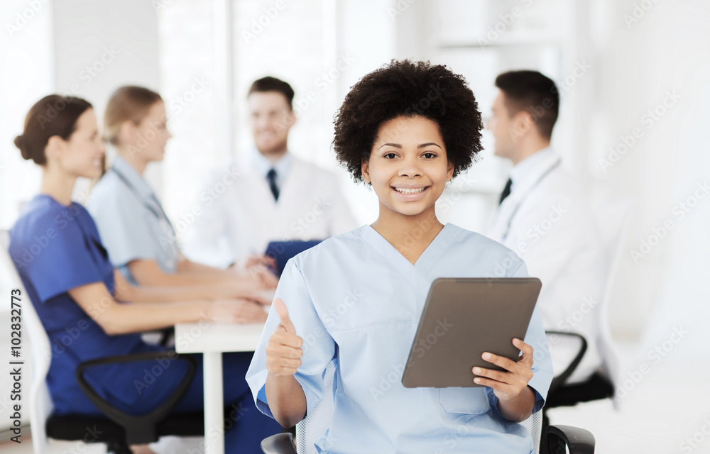 happy doctor with tablet pc over team at clinic happy doctor with tablet pc over team at clinic