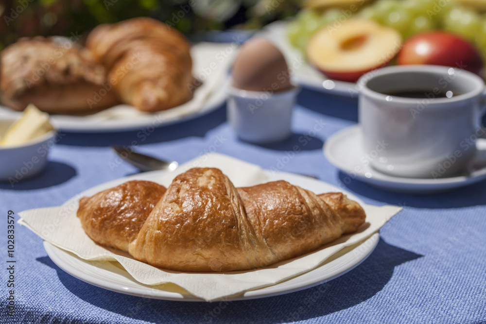 Frühstück mit Croissant, Ei, Kaffee und Obst
