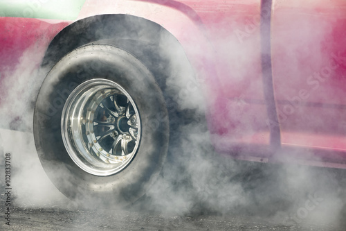 Drag racing car burns rubber off its tires in preparation for th © toa555