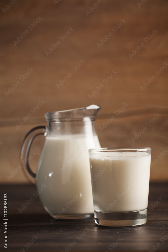 fresh milk in glass jug and glass on wooden background. Selective focus. fresh milk in glass jug and glass on wooden background. Selective focus.