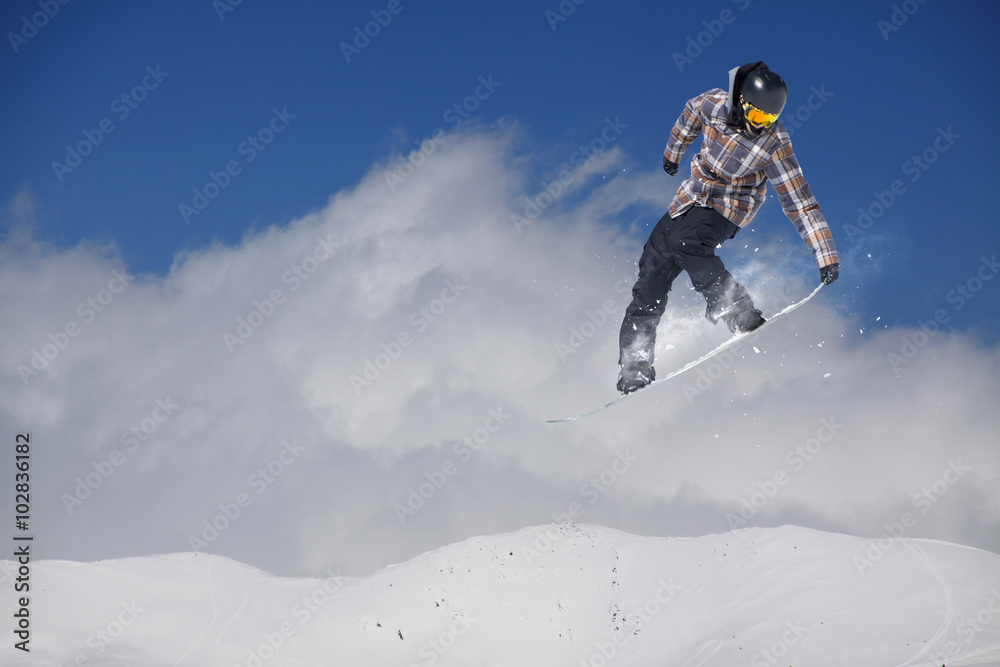 Flying snowboarder on mountains. Extreme sport.