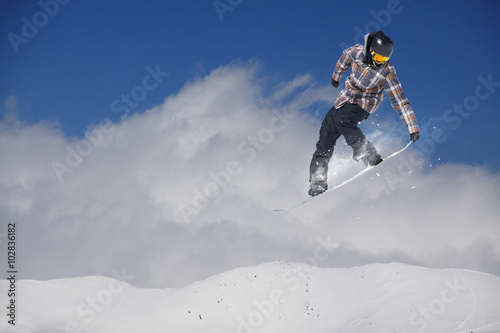 Flying snowboarder on mountains. Extreme sport.