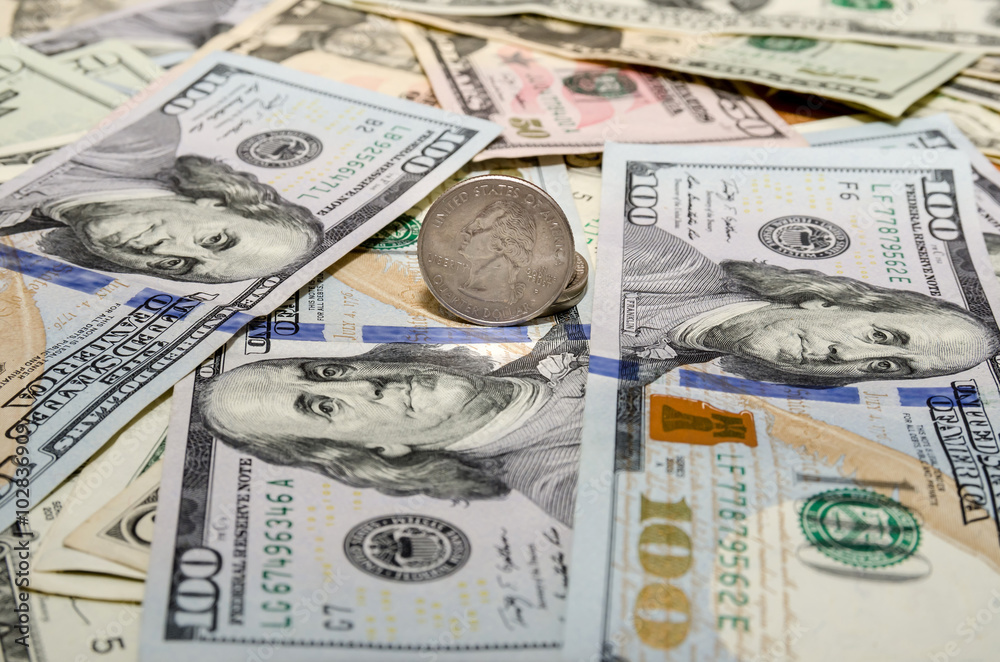 Fototapeta premium Quarter dollar coin and One Hundred Dollar banknotes currency of the United States