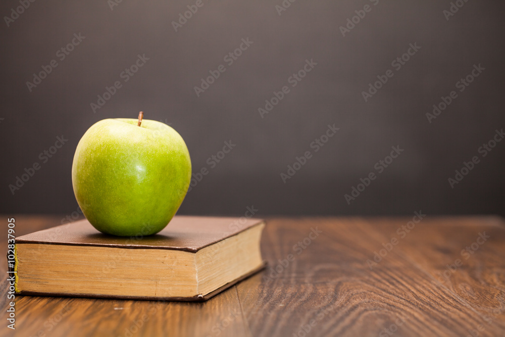 Fototapeta premium apple and book on wooden table