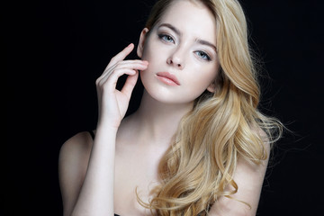 Beautiful young lady with make up face. Close-up of an attractive girl of European appearance on dark background.