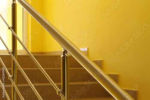 yellow residential house with golden stainless steel banister